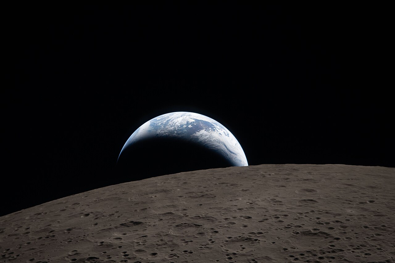 Earthset capturado por la misión Artemis II — la Tierra asomando sobre el horizonte lunar