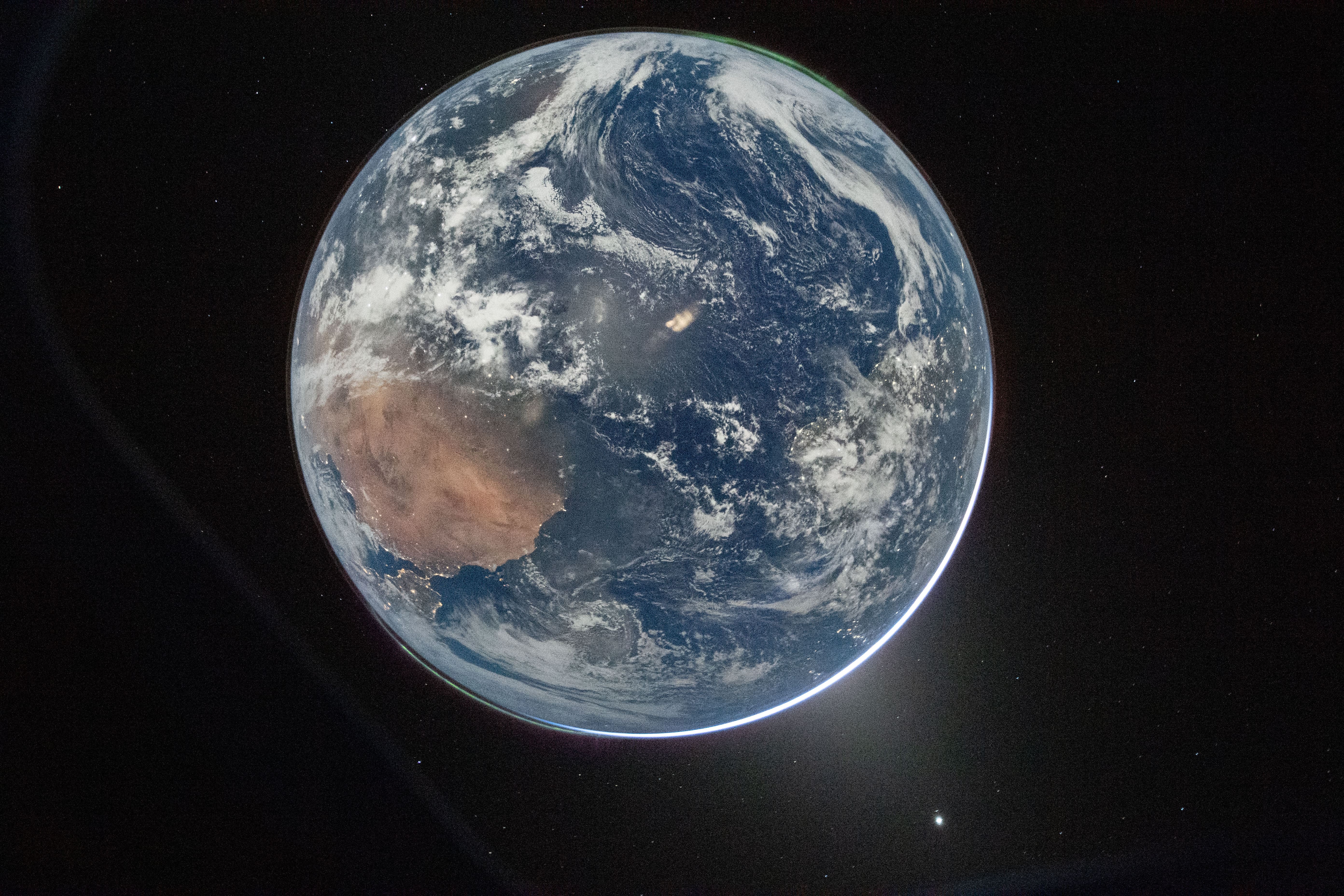 Fotografía nocturna de la Tierra tomada por la tripulación de Artemis II desde la nave Orión tras la maniobra de inyección translunar
